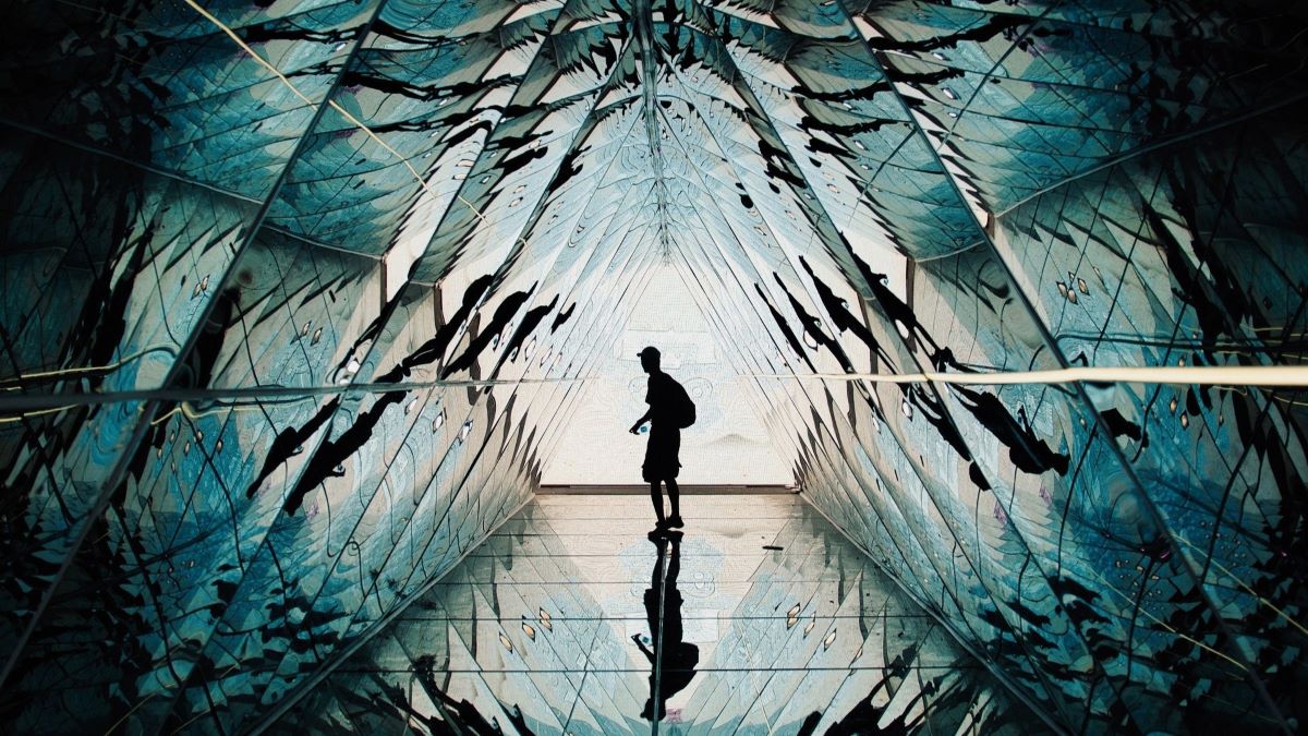 silhouette of person in futuristic hall of mirrors