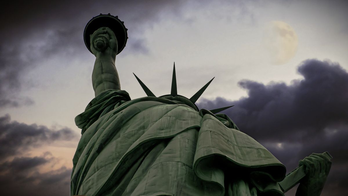 Statue of Liberty with looming storm clouds